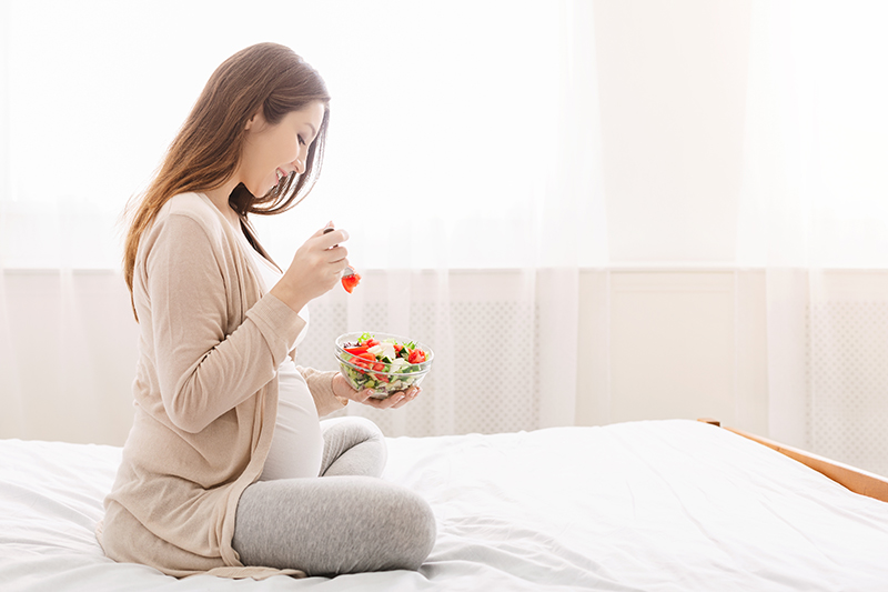 Pregnant lady eating salad